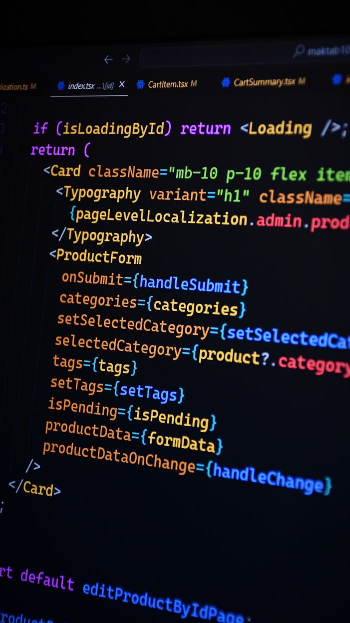 Home Close-up of JSX code on a monitor, showcasing colorful syntax used in ReactJS development.