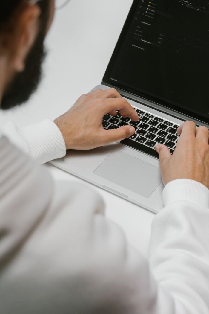 who-we-are A male programmer intensely typing code on a laptop, showcasing modern technology and software development.