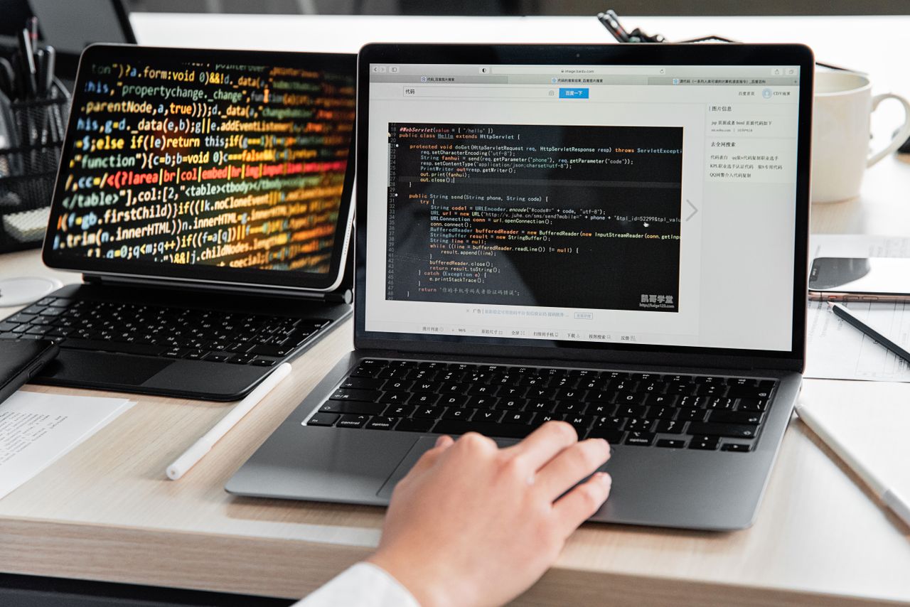 The Art of Drawing Readers In: Your attractive post title goes here A developer writing code on a laptop, displaying programming scripts in an office environment.